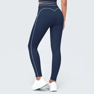 Primer plano detallado de mallas de yoga de talle alto para mujer en azul oscuro con ribete blanco.