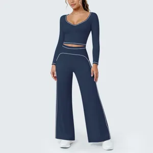Detailansicht des dunkelblauen Yoga-Sets mit kontrastierenden weißen Paspeln an Top und Hose.