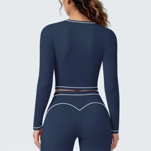 Achterkant van een donkerblauwe sportieve crop top met lange mouwen en bijpassende fitness leggings.