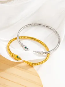 Gros plan détaillé de bracelets torsadés bicolores avec têtes de serpent et cristaux verts.
