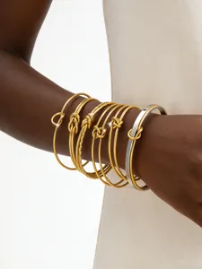 Gestapelte gold- und silberfarbene Metall-Knoten-Armreifen für Damen Modeschmuck.