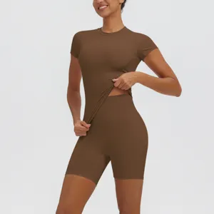 Gros plan détaillé du haut de yoga à manches courtes marron et du short moulant.