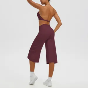 Détail de dos du soutien-gorge de yoga bordeaux et du pantalon corsaire large activewear.