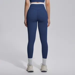 Vue détaillée du pantalon de yoga taille haute bleu foncé avec ceinture blanche contrastée.