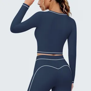Donkerblauwe sport crop-top met lange mouwen en contrastbies voor fitness en yoga detail.