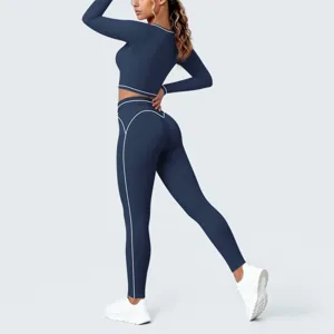 Detailed view of dark blue long sleeve crop top and yoga leggings with white contrast piping.