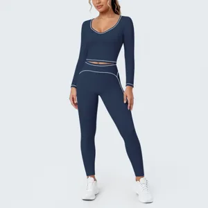 Close-up detail of the deep blue long-sleeve crop top and leggings yoga set with white piping.