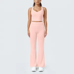 Détail de l'ensemble de sport rose avec passepoil blanc contrasté et pantalon évasé.