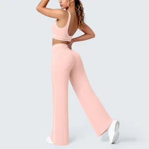Completo yoga sportivo rosa a contrasto con pantaloni a zampa e reggiseno per fitness.