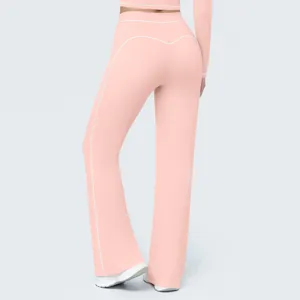 Detail view of women's pink high-waisted wide-leg yoga pants with white contrast piping.