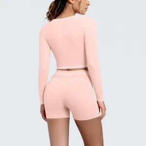Pink activewear set back detail featuring contrast white trim long sleeve crop top and shorts.