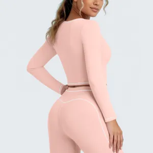 Dames sportkleding set met lange mouw crop top en yoga legging met witte bies details.