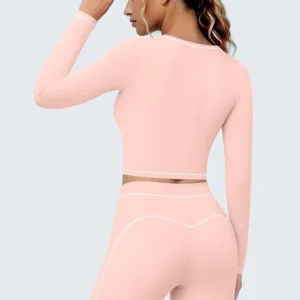 Roze langarm sportkleding set voor vrouwen met crop top en hoge taille yoga leggings.