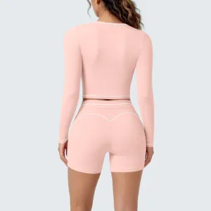 Pink long sleeve crop top yoga shorts set with contrast white piping details for women activewear.