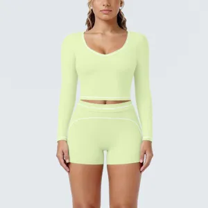 Detailed close-up of light green long-sleeve crop top and shorts yoga activewear set.