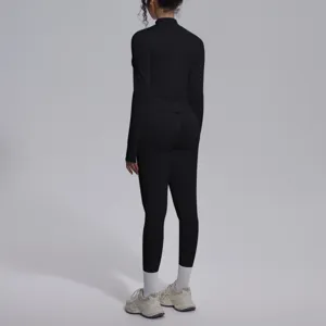 Vista di dettaglio del top sportivo a maniche lunghe nero senza cuciture con leggings.