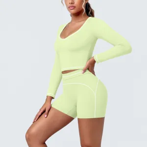 Detail view of lime green long sleeve crop top and shorts activewear set with white trim.
