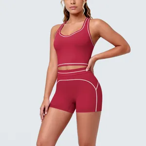 Close-up view of red athletic yoga set with white piping, showcasing brushed fabric and trim details.