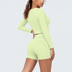 Detail view of women activewear set, long sleeve crop top and shorts with contrast piping.