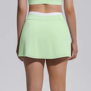 Détail de dos de la jupe de sport vert clair avec taille côtelée blanche pour tennis.