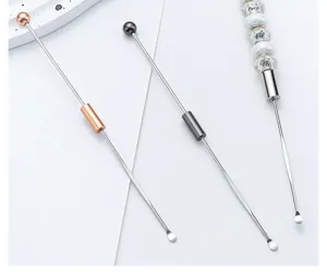 Metalen oorreiniger detail met lang handvat, kogeluiteinde en DIY kralenstaaf.