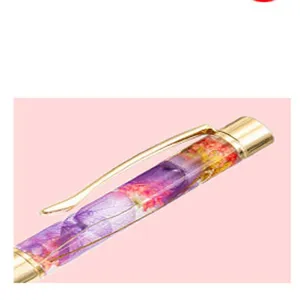 Detailfoto van DIY gedroogde bloem lege buis pen met gouden metalen clip en doorzichtige harsloop.