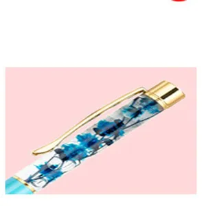 Detailopname van de DIY gedroogde bloemen kristallen pen dop en gouden metalen clip.