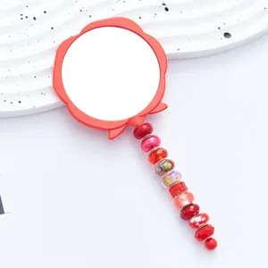 Handheld makeup mirror with cute flower design and beaded handle for daily portable use