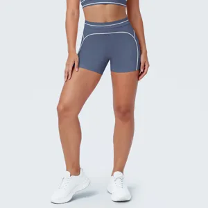 Close-up van elastische yogashorts en bh-set met contrasterende witte biesdetails.