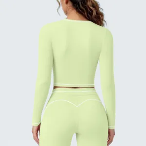 Grünes langärmliges Sport-Top und High-Waist Leggings Set mit kontrastierenden Biesen.