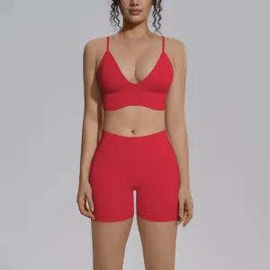 Detalle de conjunto de yoga rojo sin costuras, sujetador deportivo y short de talle alto.