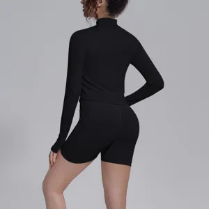 Women seamless black long sleeve sports top and biker shorts fitness yoga activewear set detail.
