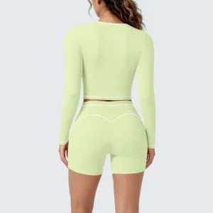 Back detail of long sleeve crop top and shorts yoga set with contrast white piping.
