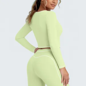 Lichtgroene sportset met lange mouwen crop top en legging met witte bies voor fitness yoga.