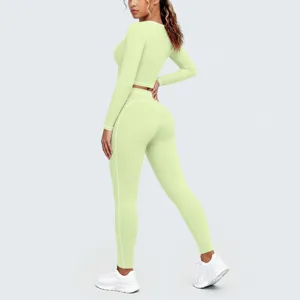 Detail view of pastel green long sleeve crop top and leggings with white contrast piping.