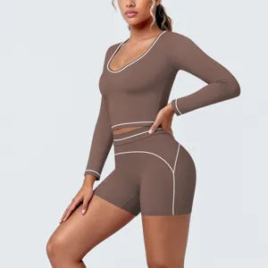 Close-up detail of brown long sleeve crop top and shorts set with white piping trim.