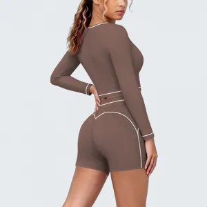 Details of the brown long sleeve activewear crop top and shorts set with stylish white piping.