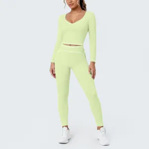 Detail view of light green athletic crop top and leggings featuring stylish white contrast piping.