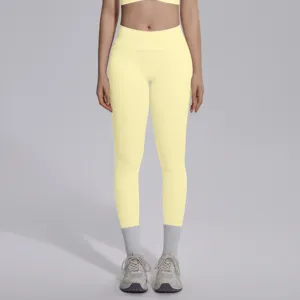 Detail view of seamless high-waisted yellow yoga leggings, breathable stretch fabric for gym.