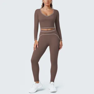 Detail view of the brown long sleeve crop top and leggings fitness set with white contrast piping.