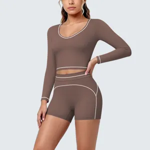 Detail view of brown long sleeve yoga crop top and shorts set with white contrast piping.