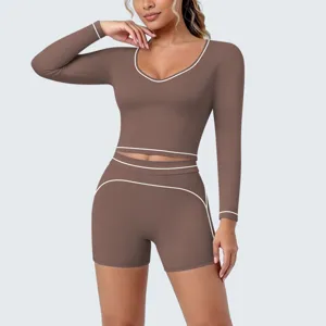 Long sleeve crop top and shorts activewear set detail in brown with elegant white piping design.