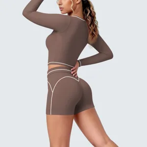 Detailed view of women long sleeve crop top and shorts yoga set with contrast white piping.