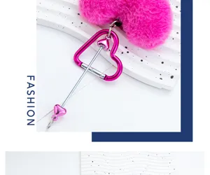 Close-up view of pink plush heart keychain with metal heart carabiner and arrow detail shot.