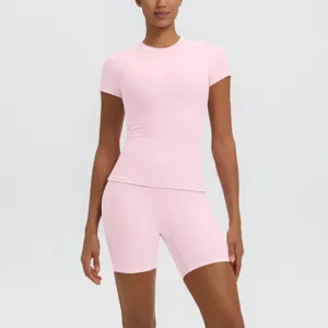 Ensemble de fitness sportif rose haut de yoga respirant à manches courtes et short de course.