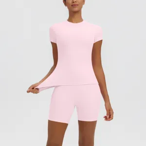 Détail de l'ensemble de sport yoga rose montrant un tissu élastique, haut et short moulants.