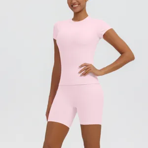 Vue détaillée du haut de sport rose respirant et du short assorti pour les entraînements.