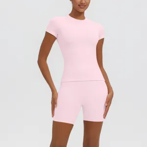 Ensemble de sport rose haut manches courtes et short taille haute pour yoga fitness.