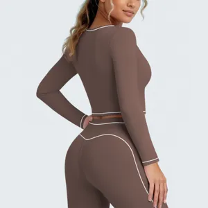 Gedetailleerd uitzicht van dames sporttop met lange mouwen en fitness legging met contrast bies.