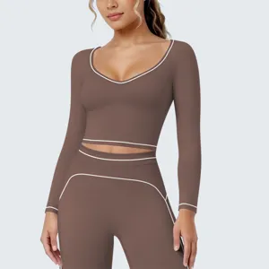 Dames bruine lange mouw crop top fitness yoga sportkleding set met witte contrastbiezen.